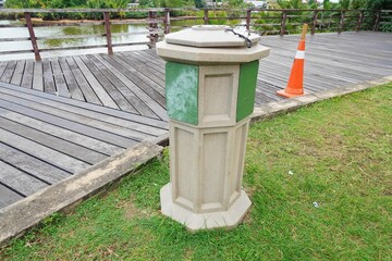 Fototapeta premium Garbage can with a closed hole trash in the park. trash container placed in a park that has a covered or closed opening