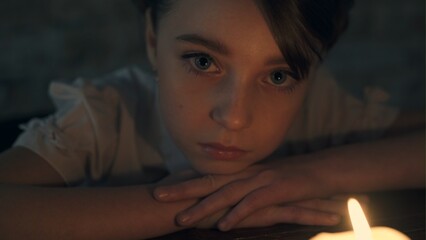 Sad little girl with a candle
