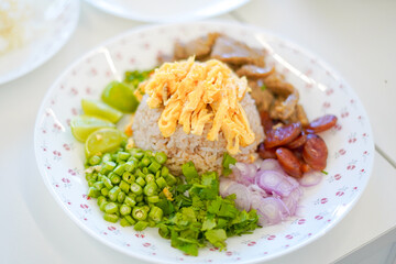 Plating Khao Kluk Kapi (Shrimp Paste Fried Rice): The shrimp paste fried rice is placed at the center of the plate.