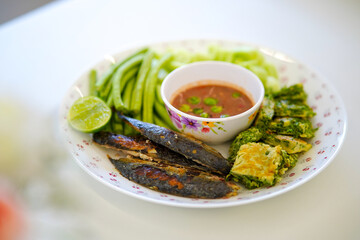 Nam Prik Kapi, a savory and spicy dip made from chili, garlic, lime juice, and shrimp paste. It’s a flavorful and healthy combination, often eaten with rice and fried mackerel.
