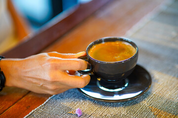 Coffee cup with hot steam on brown wood table in cafe shop.