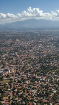Aerial View Of City With Residential Buildings Roads And Mountains In The Background