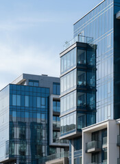 Obraz premium Modern glass apartment buildings with balconies in daylight 