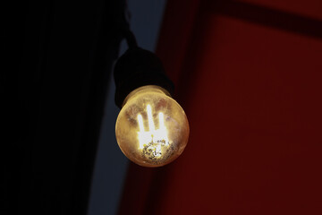 The light comes from an old, worn, yellow, round light bulb.