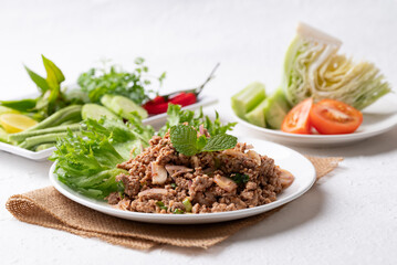 Local Thai food, Spicy minced pork salad (Larb Moo) eating with fresh vegetables on white background