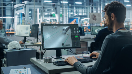 Advanced Manufacturing: Team of Engineers Collaborate on Design of Robotic 3D Assembly Line. Screen Shows Software Automated Production Process, Optimizing Industrial Facility Layout