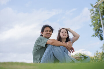 Relax and wellness concept with couple sit in garden and mountain background at chiangmai thailand in raining season