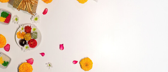 Minimalist Diwali setup with sweets and flowers on a white background