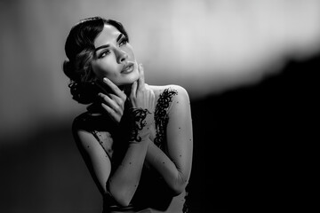 Retro style bw portrait of thoughtful attractive woman posing in elegant dress. Elegant woman in...
