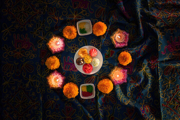 Diwali festival sweets and flowers arranged in a circular pattern