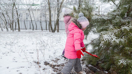 Active recreation with children in winter on cold days. Happy siblings having fun with snow