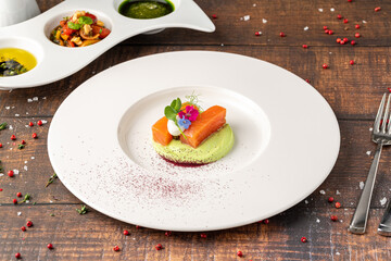 Gourmet salmon fillet with green puree and edible flowers