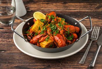 Cooked crayfish with corn and herbs in a serving pan
