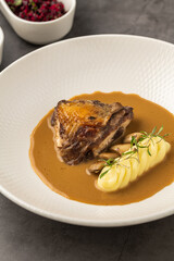Roasted meat with mashed potatoes and brown sauce on plate