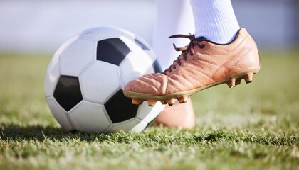 Close-up of a soccer player's foot about to strike a ball.