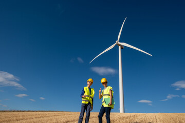 Renewable energy engineers wearing safety vests and helmets are giving vocational training to a...