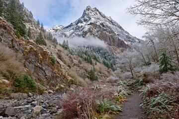 Frosty valley path leads to snow-capped peak