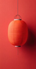 Obraz premium A vibrant red paper lantern hangs against a bold red background, showcasing its intricate folds and simple elegance.