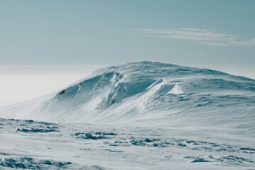 Fototapeta premium Snow-covered mountain peak under a pale sky