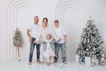 Family father, mother, son and daughter celebrate Christmas together, happy, stylish