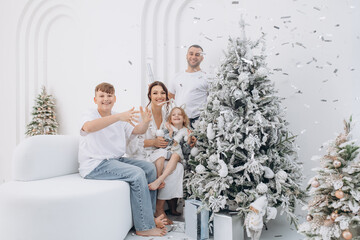 Family father, mother, son and daughter celebrate Christmas together, happy, stylish
