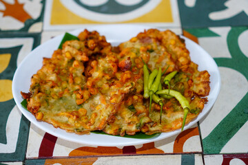 Enjoy Delicious Bakwan Fritters with Green Chili Peppers on Tile Table