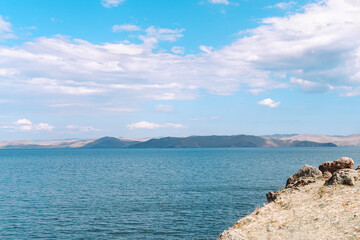 Majestic view of rocky landscape under a vibrant blue sky filled with fluffy clouds