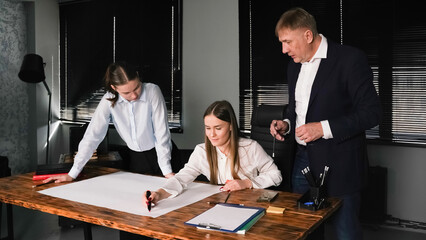 Group of people collaborating on a project in a modern office setting during daylight hours