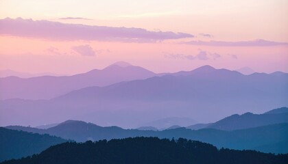 Mountain range receding into a pastel sunset sky, fading from deep blue to pink. Soft clouds adorn the skyline in this landscape