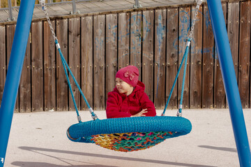Caucasian smiling child of 8 9 years swinging on round seesaw