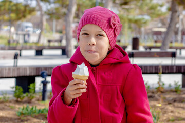 Portrait of happy and smiling caucasian little girl of 8 9 years eating ice cream cone outside