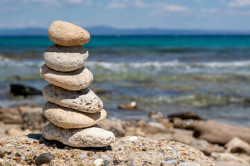 stack of stones on beach in greece island