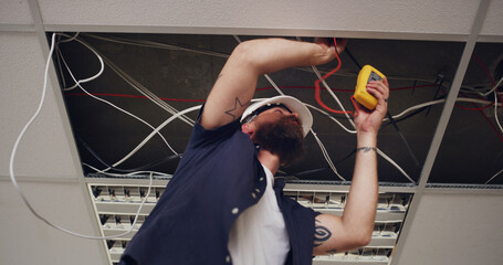 Electrician, man and meter with light wires for construction, remodeling project or renovation....