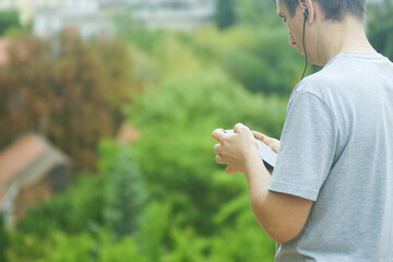Obraz premium Calm man using meditation app or mindfulness audio content on smartphone in park. Symbolizes digital wellness and stress management for mental health support. Emotional balance and self-care practices