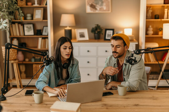 Content creators recording podcast using laptop at home - Powered by Adobe