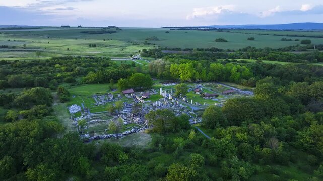 Distant drone view of Nicopolis ad Istrum at golden hour, as the sun illuminates the Roman city ruins