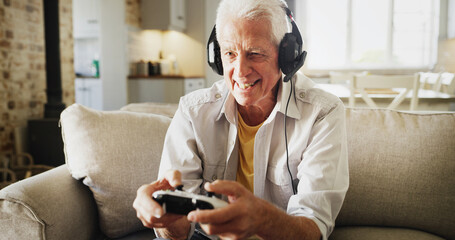 Senior, happy man and playing with video games on sofa for competitive action or esport in home. Elderly, male person or gamer with smile, controller or headphones for online competition in house