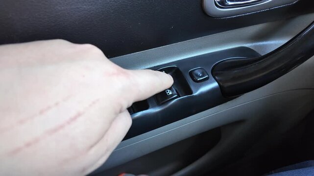 analog window lift buttons. man opens window in car. old buttons in car. man presses window lowering button. window lifter. window lifters in a car buttons