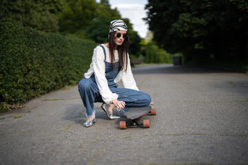 Young woman skating in sunlit park wearing stylish outfit