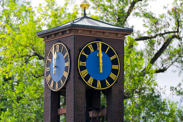 Close-up of clock tower of kindergarten Döltschiweg showing twelve o'clock position with tree in...