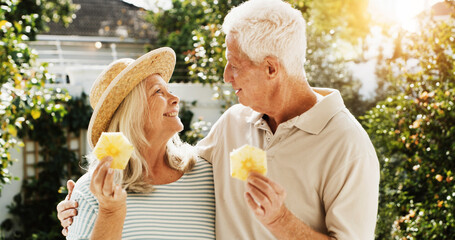 Outdoor, laughing and senior couple with fruit, patio or bonding on break, wellness or healthy diet. Home, old woman and elderly man with pineapple on weekend, romance or people with humor for joke