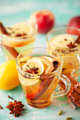 Homemade Wassail Mulled Apple Cider with Lemon and Spices in glasses. Winter alcoholic hot drink.