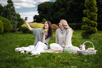 Friends enjoying a sunny picnic while capturing joyful moments together
