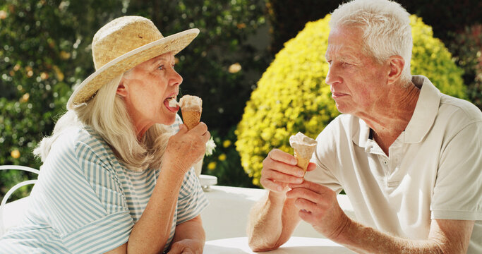 Outdoor, senior couple and eating ice cream for sweet treat, bonding together and summer holiday. Retirement, elderly people and relax with gelato cone in garden for dessert snack or anniversary date