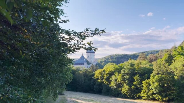 Karl&scaron;tejn Castle revealed through green foliage