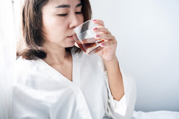 Stressed Asian woman drinking whiskey glass, alcoholism and addiction concept, mental health and...