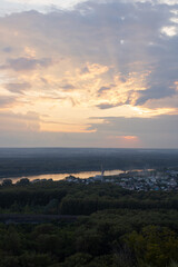Sunset over the river, forest, industrial part of the city of Ufa. Bashkiria. Houses and cranes are visible in the blur. Summer evening
