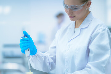 A geneticist carefully adjusts the volume on a micropipette, preparing to dispense a precise amount...