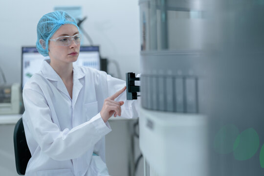 A medical technologist loads a sample rack into an automated immunoassay analyzer, initiating the biomarker testing process for diagnostics in a certified laboratory.