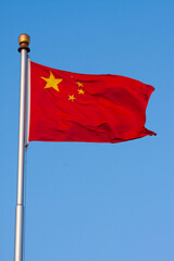 The Red Dragon Soars: The National Flag of the People's Republic of China Waving Proudly Against a Clear Blue Sky in Beijing